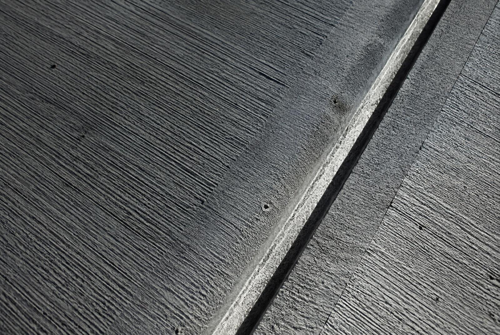 Close-up of broom-finished concrete and a tooled control joint